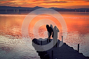 Family taking pictures in the sunset of the calm waters of the Albufera de Valencia, Spain