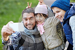 Family taking selfie with smartphone outdoors