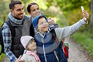 Family taking selfie with smartphone in woods