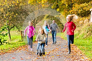 Family taking walk in autumn fall forest