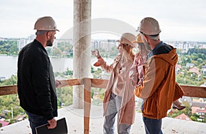 Family talking with builder at construction site.