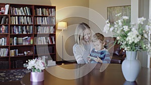 Family, technology and motherhood concept - happy smiling young mother with little baby and smartphone at home 4k