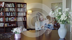 Family, technology and motherhood concept - happy smiling young mother with little baby and smartphone at home 4k