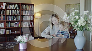 Family, technology and motherhood concept - happy smiling young mother with little baby and smartphone at home 4k