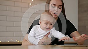 Family, technology and motherhood concept - happy smiling young mother with little baby and tablet pc computer at home