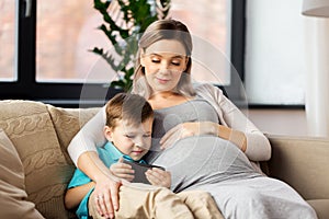 Pregnant mother and son with smartphone at home