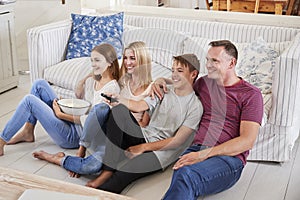 Family With Teenage Children Sitting On Sofa Watching TV Together