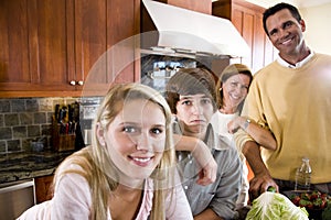 Family with teenager kids in kitchen, boy frowning