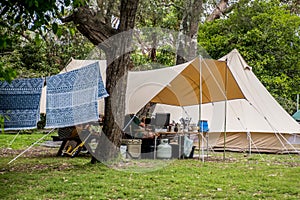 Family tent setup at the campsite surrounding by bush forest in a holiday caravan parlk. Family vacation travel camping glamping