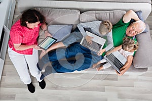Family With Their Laptop And Digital Tablet At Home