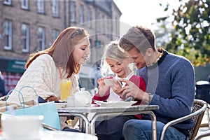 Family of Three Looking at a Smartphone