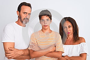 Family of three, mother, father and son standing over white isolated background skeptic and nervous, disapproving expression on