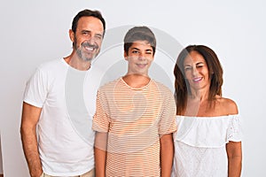 Family of three, mother, father and son standing over white isolated background winking looking at the camera with sexy