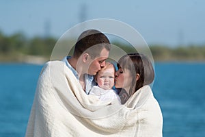 The family of three people has a rest outdoors