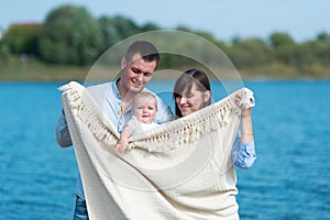 The family of three people has a rest outdoors