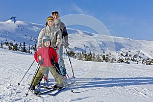 Family of three people learns skiing together