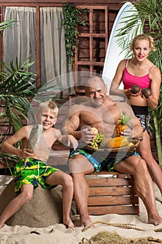 A family of three on a sandy beach with a basket