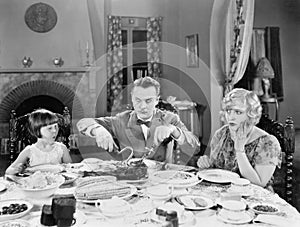 Family of three sitting together having dinner