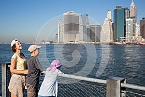 Family of three are standing on the quay at autumn photo