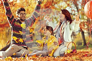 Family throwing autumn leaves