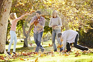 Family Throwing Autumn Leaves In The Air