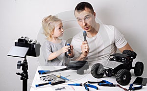 Family time: Dad and daughter repair the rc radio controlled buggy car model and lead a video blog.