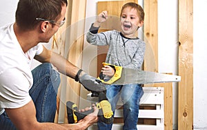 Family time: Dad shows his son hand tools, a yellow screwdriver and a hacksaw. They need to drill and drill boards for