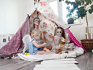 Family time: Mom and some of the sisters` children play at home in a children`s homemade tent.