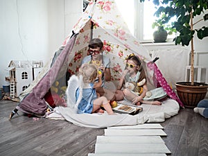 Family time: Mom and some of the sisters` children play at home in a children`s homemade tent.