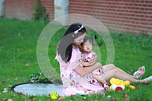 Family time, Mother hug her little baby girl on the lawn