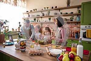 Family time for parents and daughters at the modern rustic kitchen they preparing the healthy dinner together at the