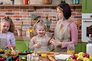 Family time for parents and daughters at the modern rustic kitchen they preparing the healthy dinner together at the