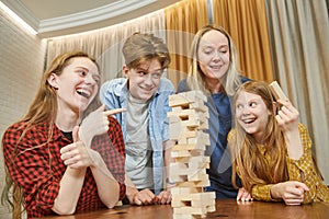 Family time spending. Parents and childrens playing in table game