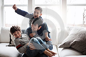 Family time is a whole lotta fun. two adorable little boys having fun with their father at home. photo