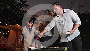 Family together camping in garden, Mom dad and daughter grill food. Divergence.