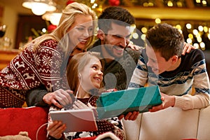 Family together in Christmas eve with gift in boy`s hands