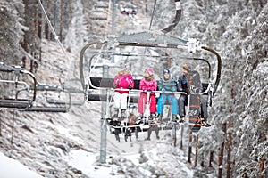Family together in ski chair going to ski terrain