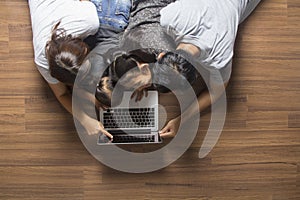 Family top view lying on floor using laptop computer