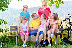 Family on tour with bikes having rest on bench