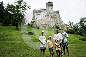 Family tourists against Bran Castle in Romania. Dracula medieval castle in Carpathians, Transylvania