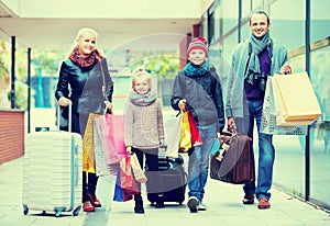 Family of tourists carrying shopping bags