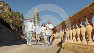 A family of tourists, father, mother and two children walk city use a mobile navigation application,