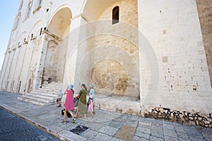 Family of tourists walking against Basilica of Saint Nicholas in Bari, Puglia, South Italy