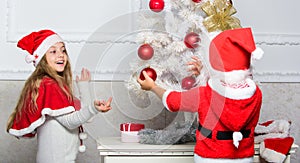 Family tradition concept. Children decorating christmas tree together. Siblings busy decorating. Boy and girl decorating