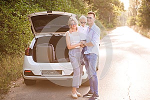 Family, transport, safety, road trip concept - happy man and woman with little child travel.