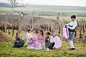 Family with trash bag collecting garbage while cleaning in the vineyards . Environmental conservation and ecology, recycling