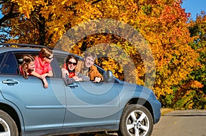 Family travel in car on autumn vacation, happy parents and kids have fun in trip