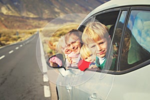 Family travel by car- happy father with kids on road in mountains