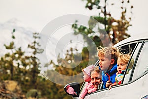 Family travel by car- happy mother with kids driving in mountains