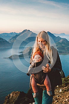 Family travel mother hiking with baby carrier healthy lifestyle outdoor family time summer vacations in Norway